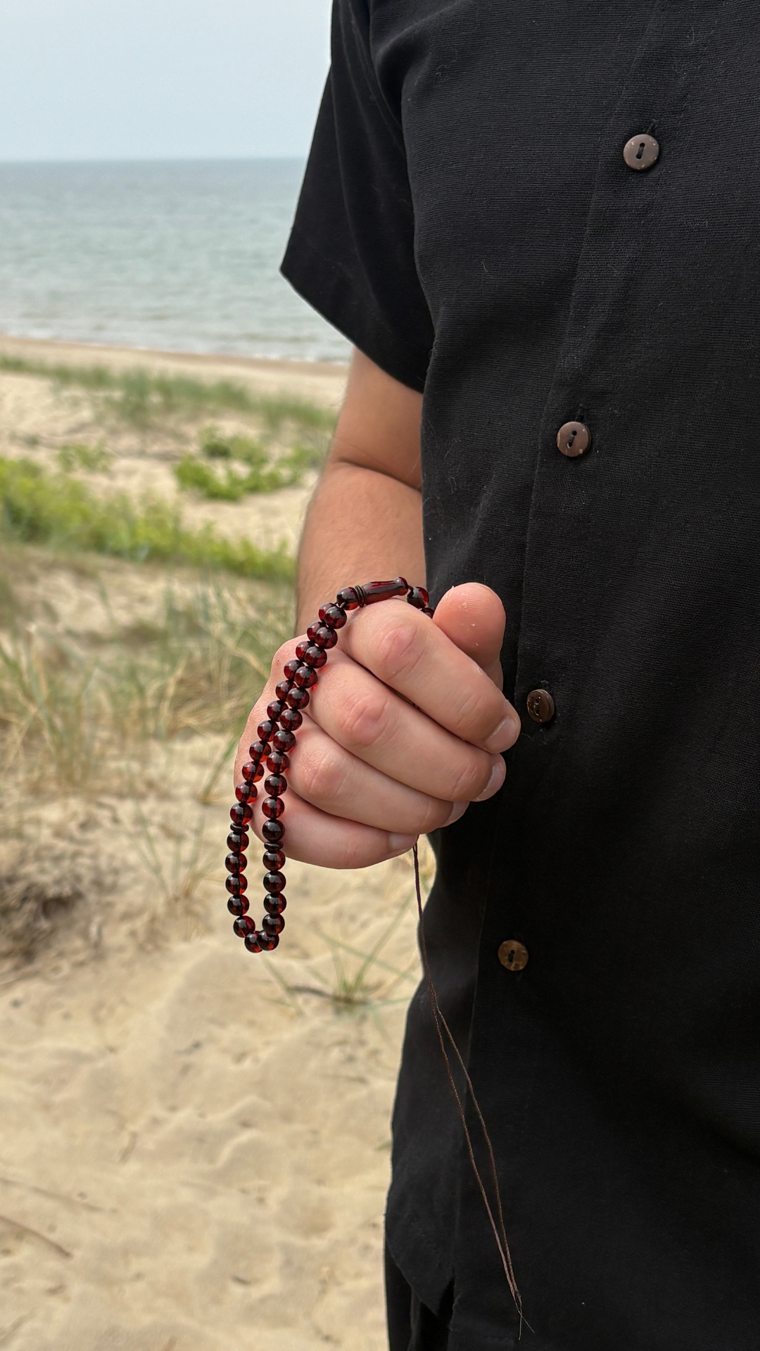 Deep cherry amber tasbih held close